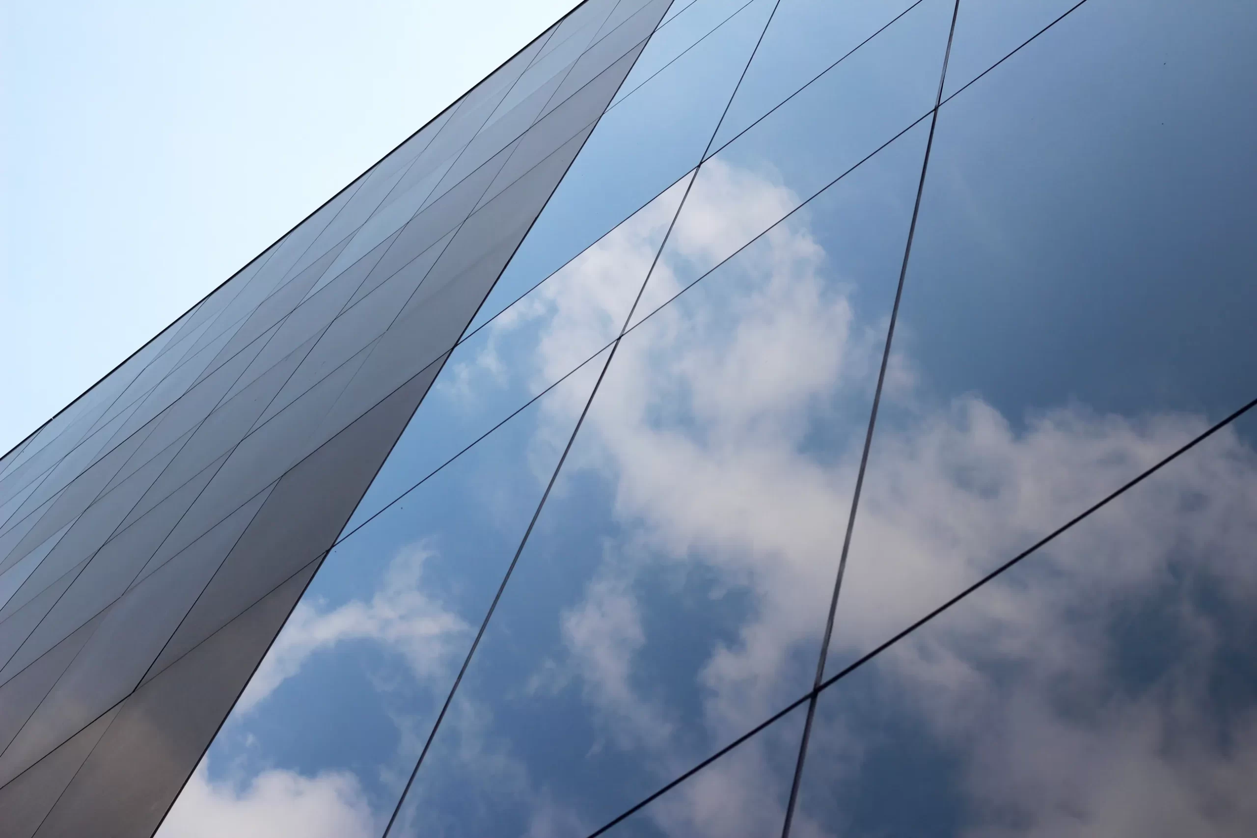 low-angle-shot-glass-high-rise-business-building-with-reflection-clouds-sky-it